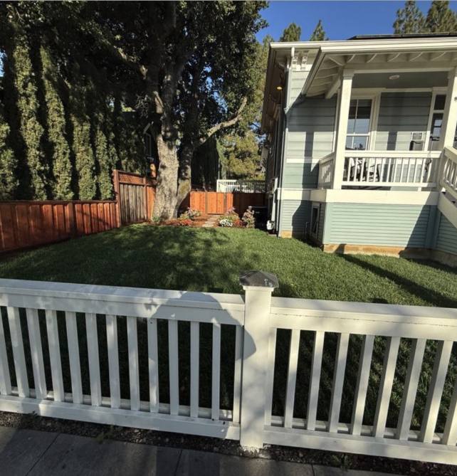 Green front lawn behind a white picket fence